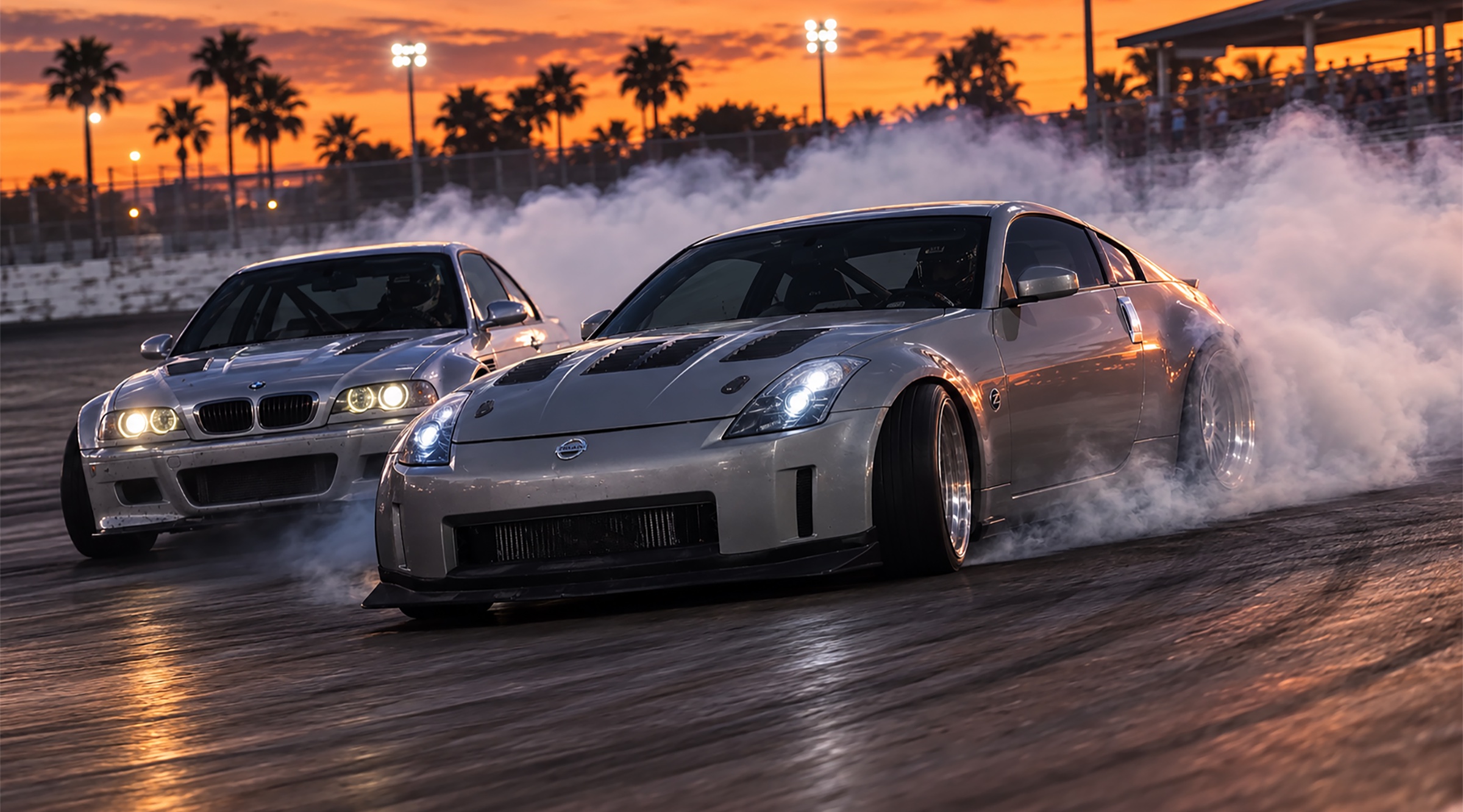 Two drift cars holding controlled tandem slides at sunset
